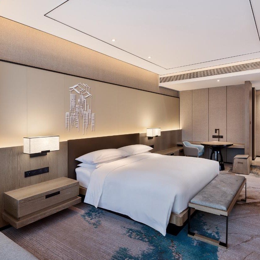Guestroom casegoods — headboard wall, nightstands, desk and luggage bench